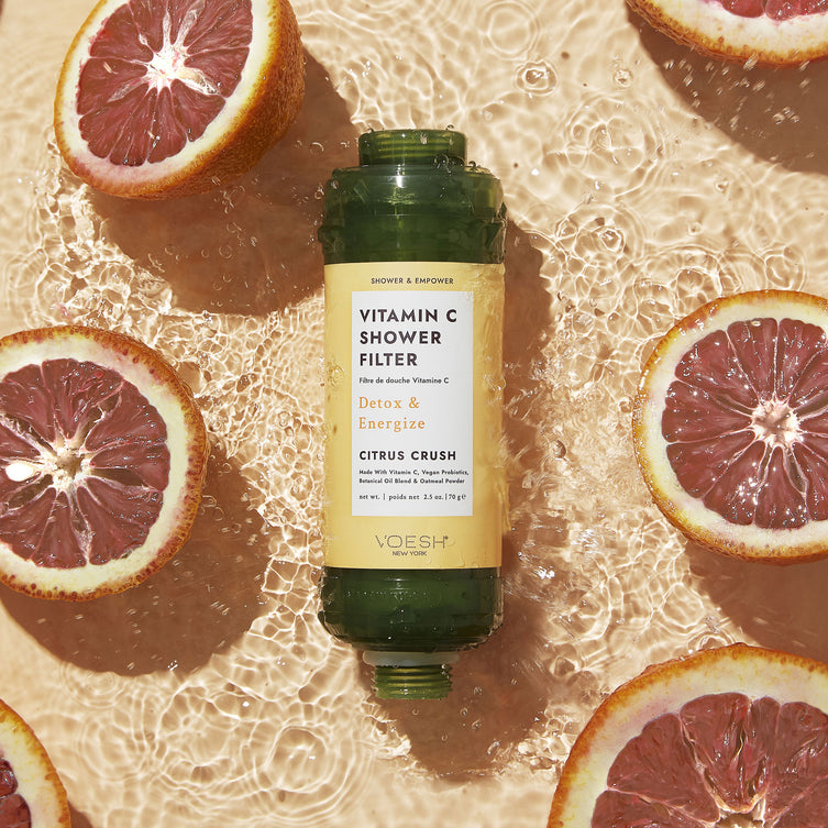 Vitamin C Shower Filter Citrus Crush on an orange water background with sliced oranges.