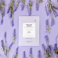 Peeling Sock packet on purple background with lavender surrounding it