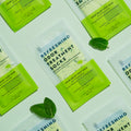 Refreshing Odor Treatment Socks on light green background in symmetrical pattern with mint leaves