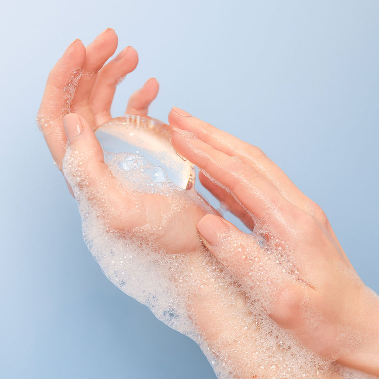 A pair of hands lathered with the VOESH Crystal Clear Handsoap with a light blue background