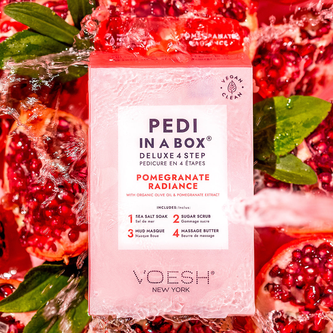 Pedi in a box 4 step pomegranate radiance box in water with pomegranate fruits surrounding it