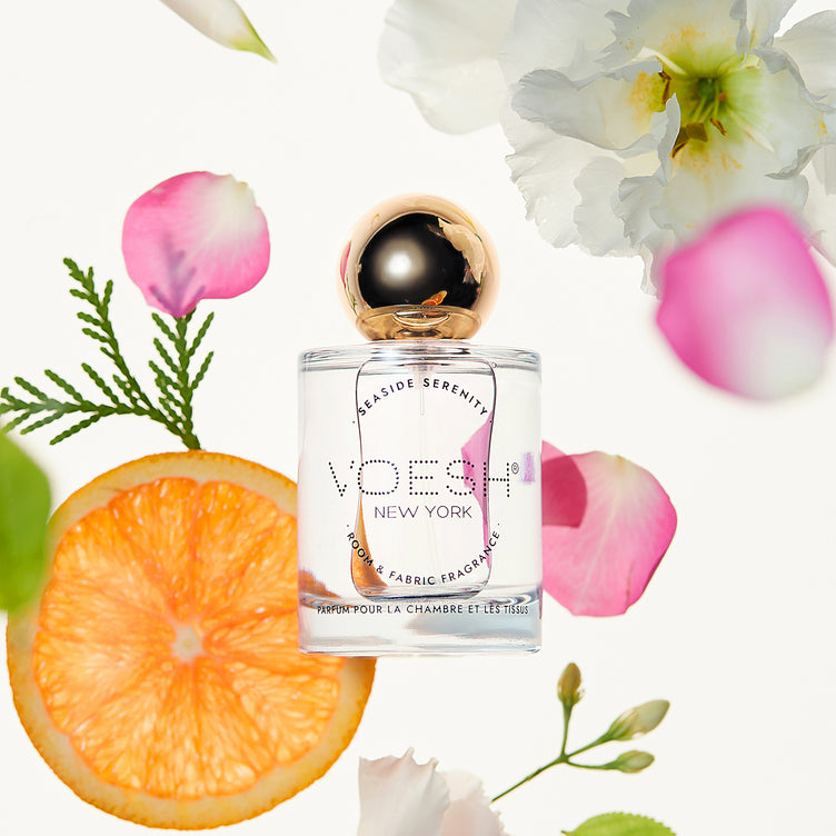 Room & Fabric Fragrance pictured on a white background with orange slices and flowers.