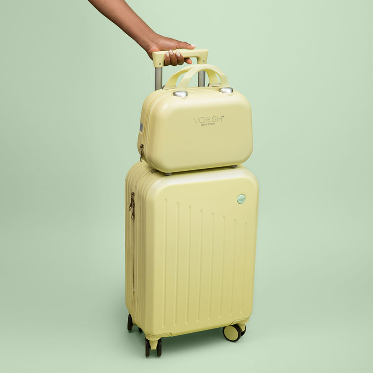 VOESH Carry-On Luggage Set stacked on top of each other with an arm holding the handle