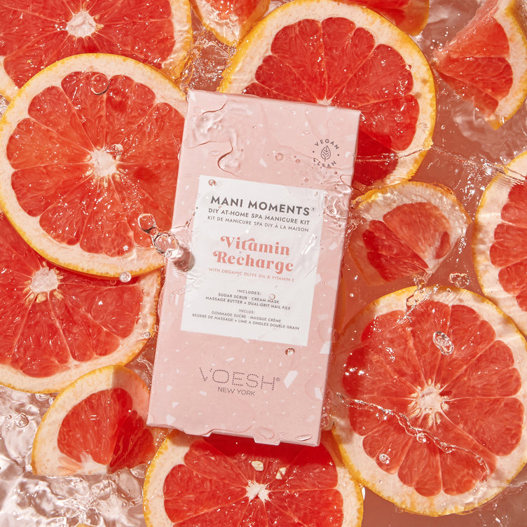 Mani Moments Vitamin Recharge on a water background with sliced grapefruit.