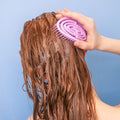 scalp massager being used on red hair