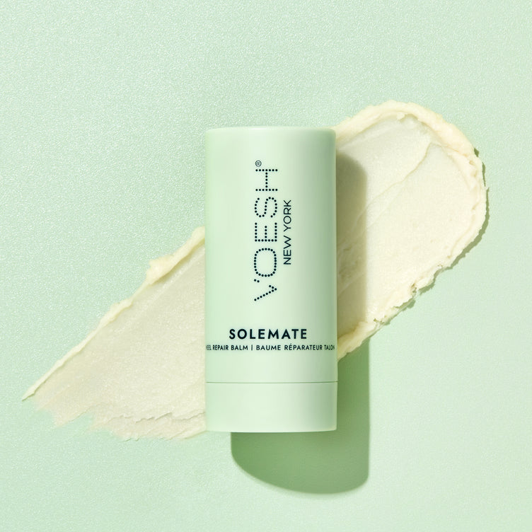 Solemate Heel Repair Balm pictured on top of its balm texture on a green background.