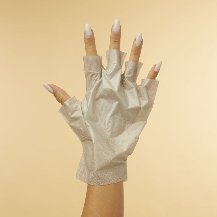 Woman's hand wearing Collagen Gloves With Peppermint & Herb Extracts with fingertips removed on orange background