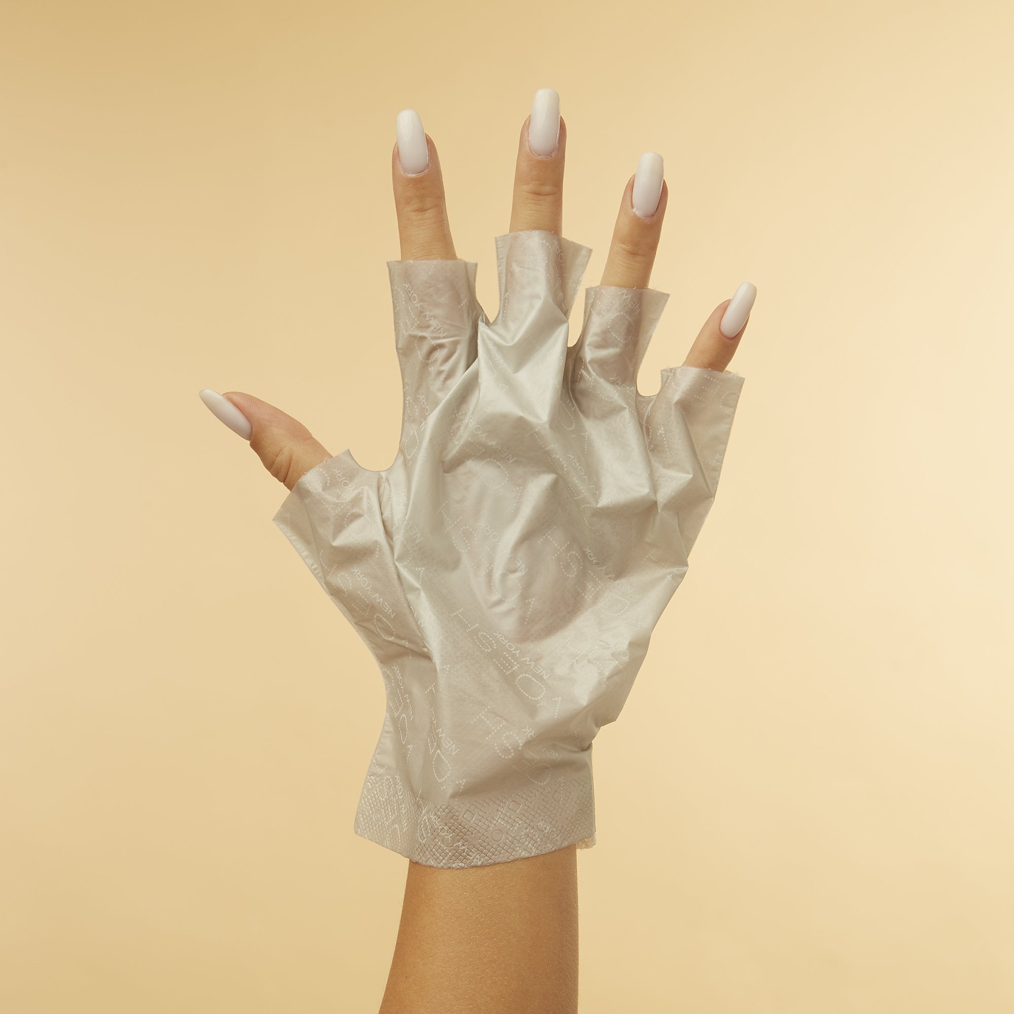 Woman's hand wearing Collagen Gloves With Peppermint & Herb Extracts with fingertips removed on orange background