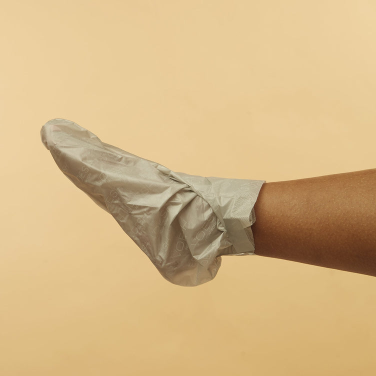 woman wearing Collagen Socks with Peppermint & Herb Extracts on orange background