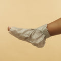 woman wearing Collagen Socks with Peppermint & Herb Extracts tip removed on orange background