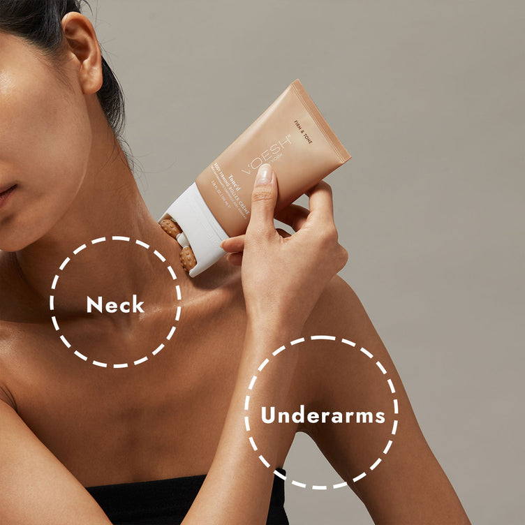 Woman using Tone’d Body Firming Roller Crème on the side of her neck, pictured on a gray background.