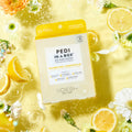 Sparkling Limoncello pedi in a box O2 fizz on background with lemons and flowers