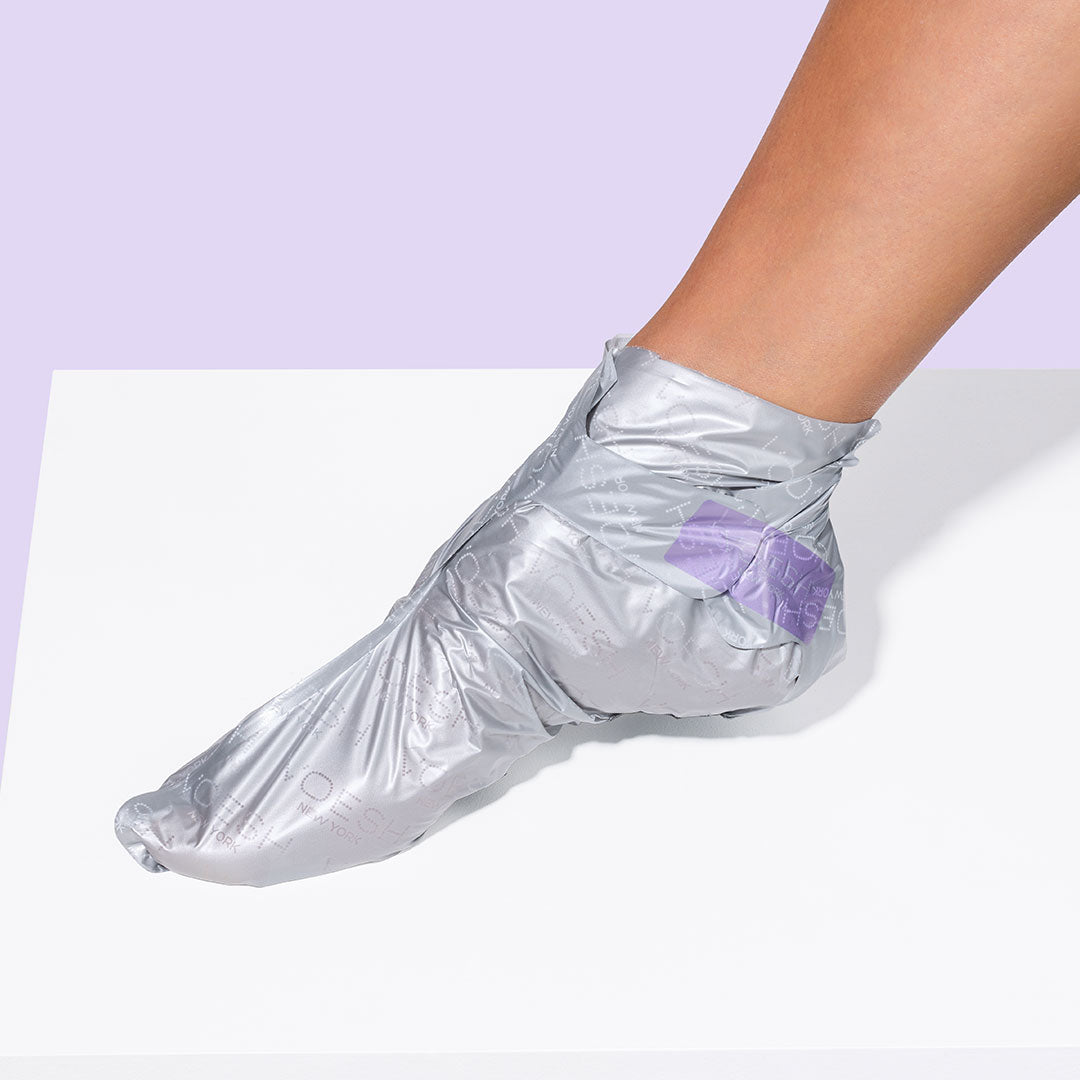 Image of woman's foot wearing the peeling sock on purple