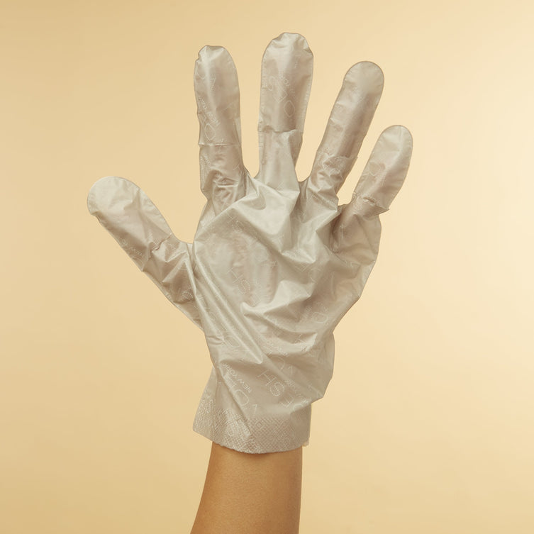 Woman's hand wearing Collagen Gloves With Peppermint & Herb Extracts on orange background
