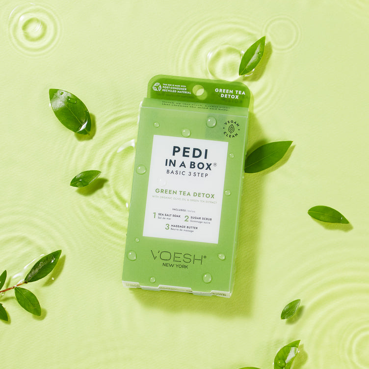 Pedi in a box 3 step green tea detox box on green background in water with green tea leaves
