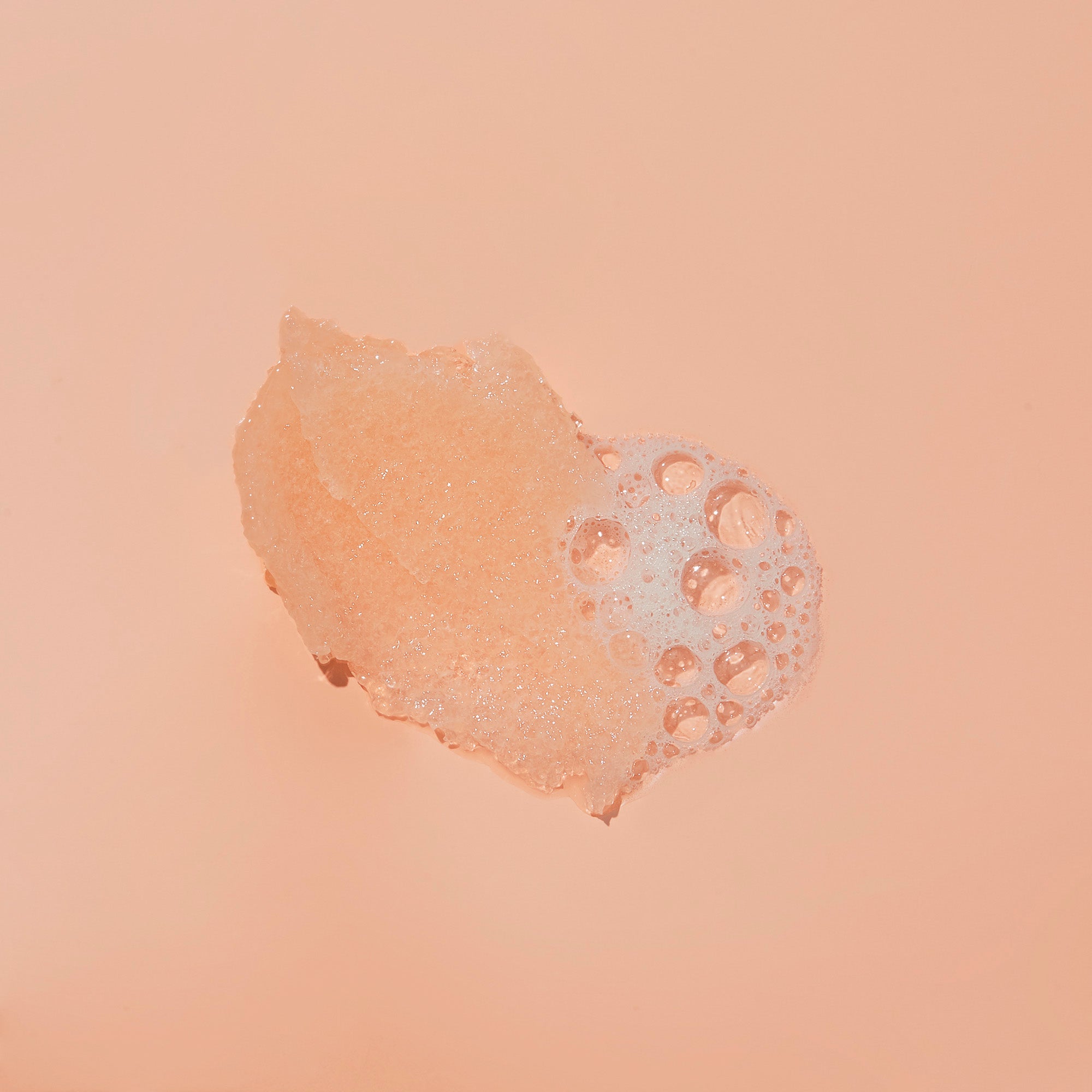 Texture of sugar scrub with bubble on orange background